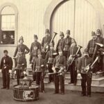 Historische Blaskapelle in Uniformen mit Blechblasinstrumenten vor einem Gebäude