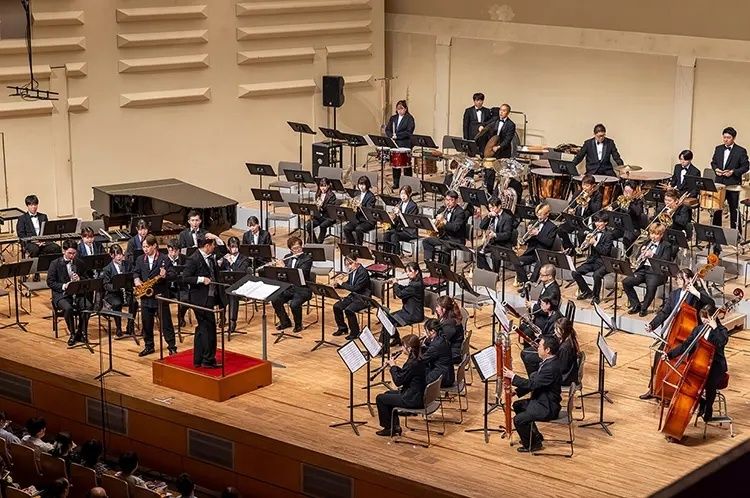 Dirigent leitet ein großes Blas- und Sinfonieorchester im Konzertsaal